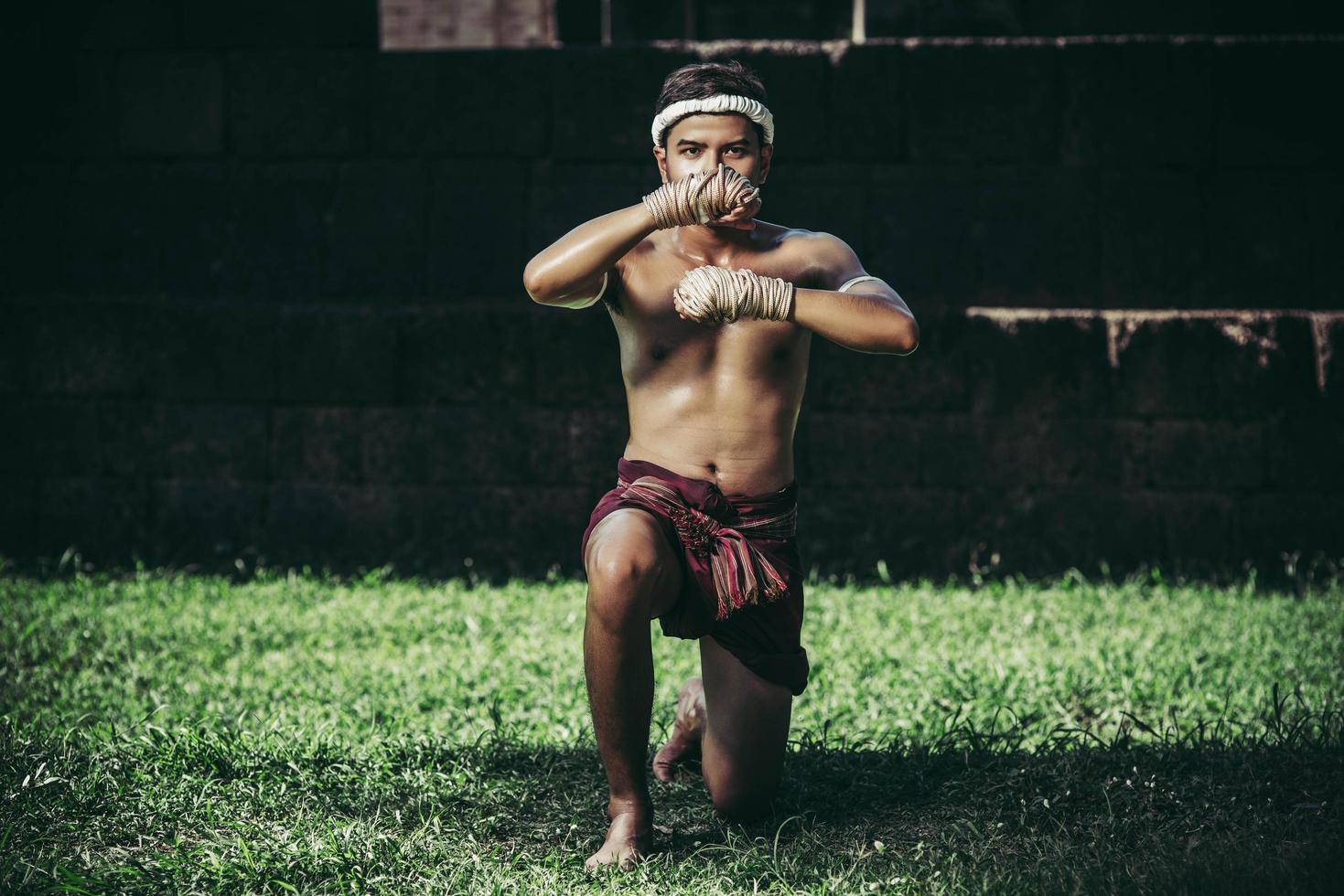 un pugile gli legò una corda in mano ed eseguì un combattimento, le arti marziali del muay thai. foto