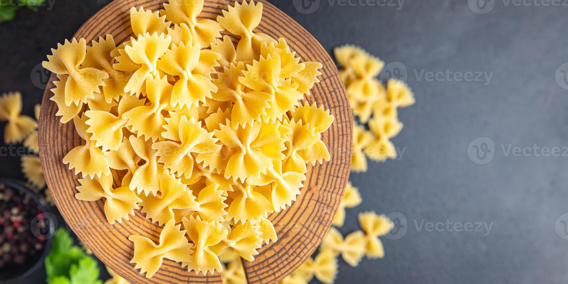 Farfalle pasta cruda fiocchi di grano duro farina sana foto