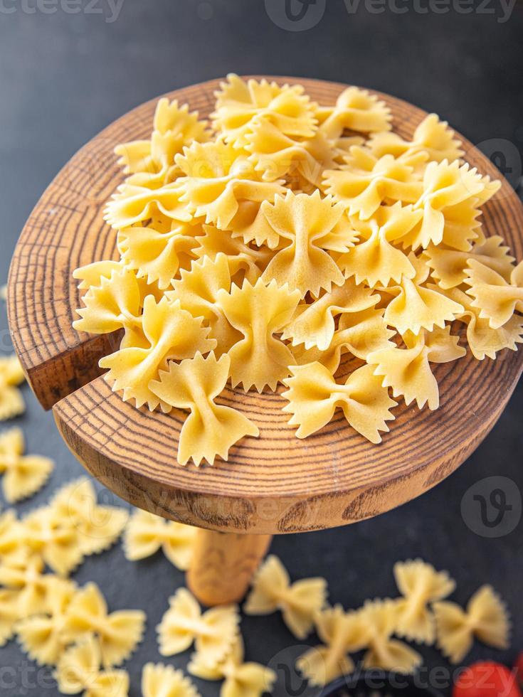 Farfalle pasta cruda fiocchi di grano duro farina sana foto