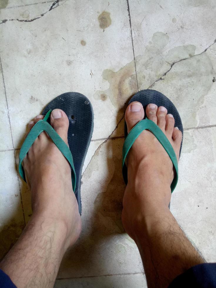 sandali rotti di un uomo su uno sfondo di pavimento sporco foto