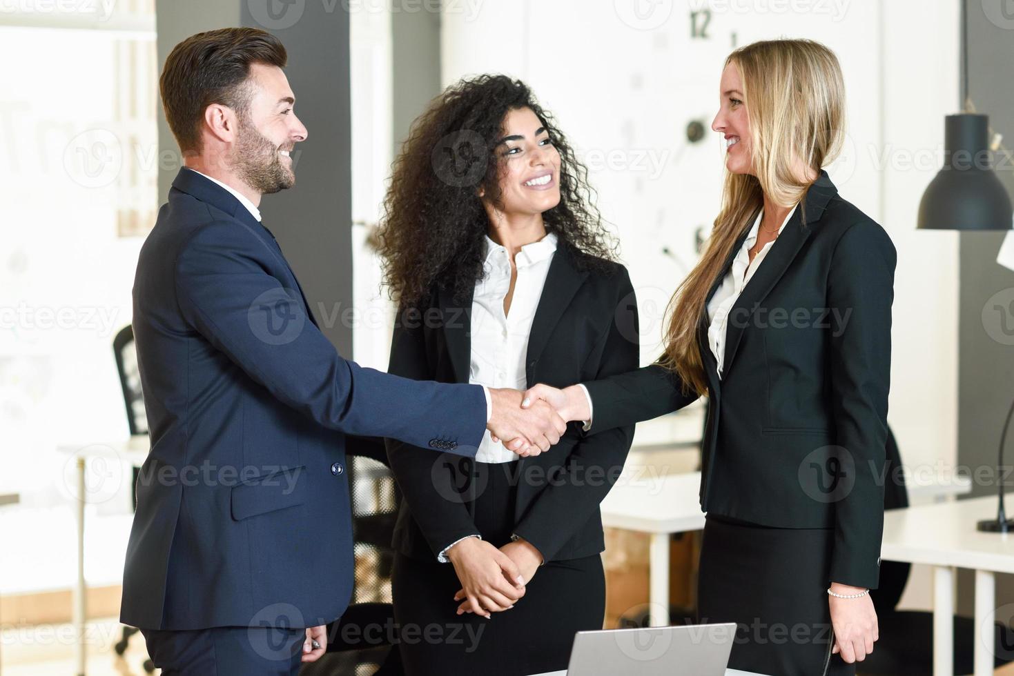 uomo caucasico e donna che si stringono la mano indossando la tuta. foto