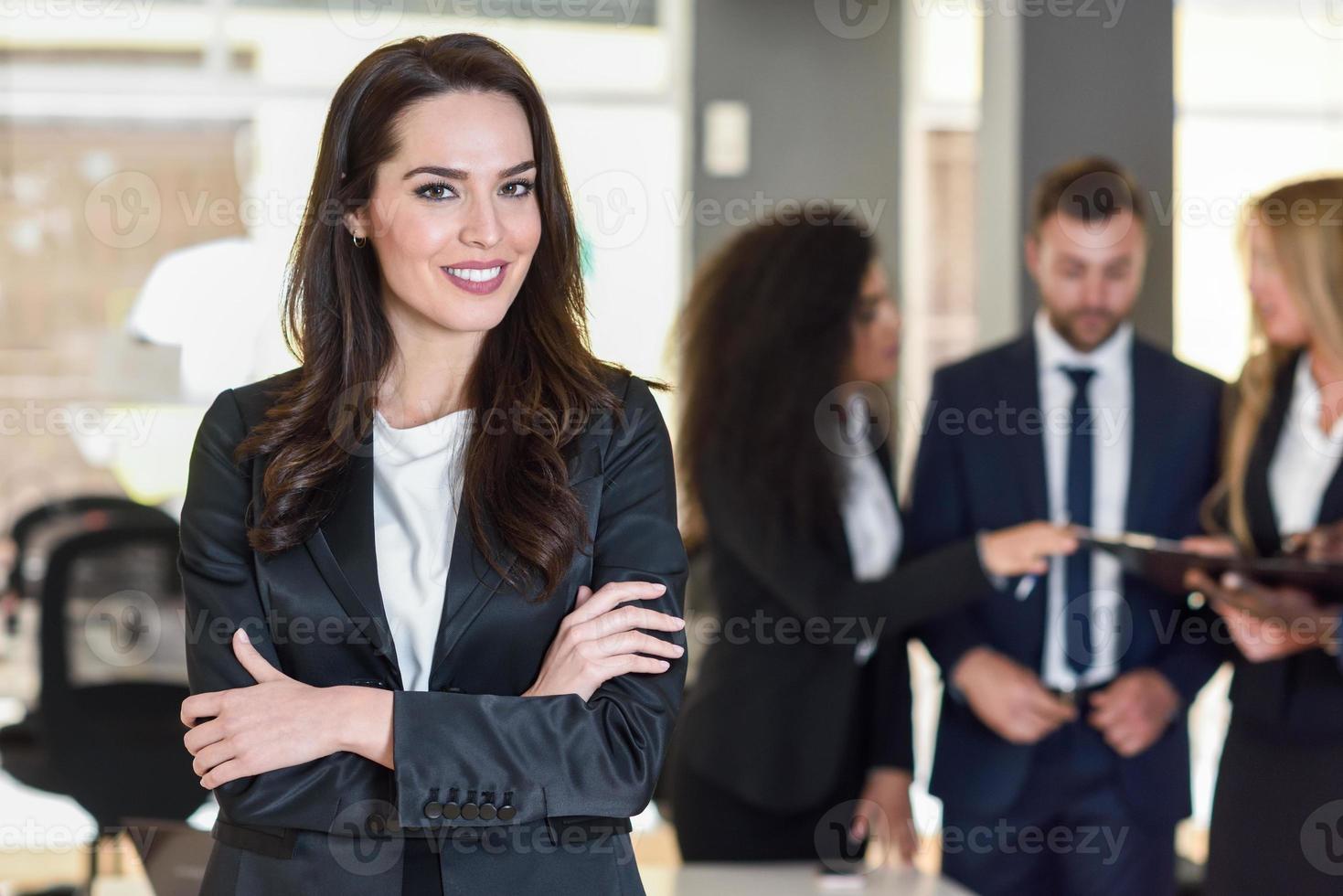 leader donna d'affari in un ufficio moderno con uomini d'affari che lavorano in background foto