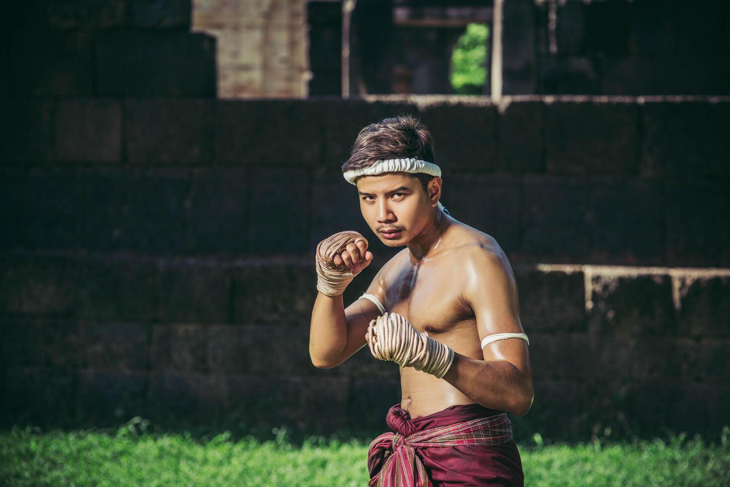 un pugile gli legò una corda in mano ed eseguì un combattimento, le arti marziali del muay thai. foto