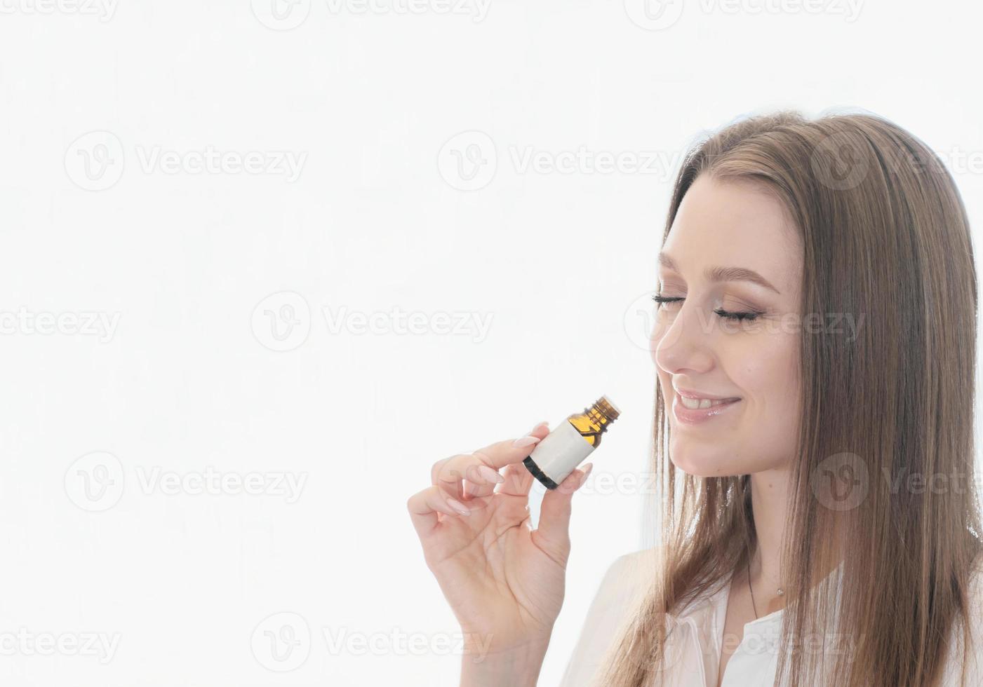 la donna sorridente annusa l'olio di eucalipto per aumentare l'immunità e la salute respiratoria. concetto di medicina alternativa. copia spazio per il testo foto
