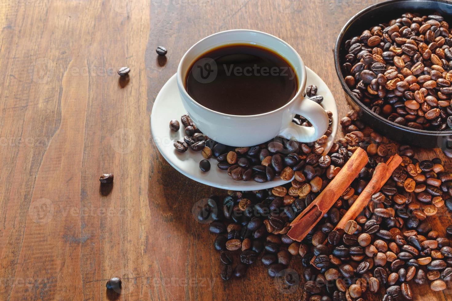 tazza di caffè e fagioli sul vecchio tavolo in legno foto