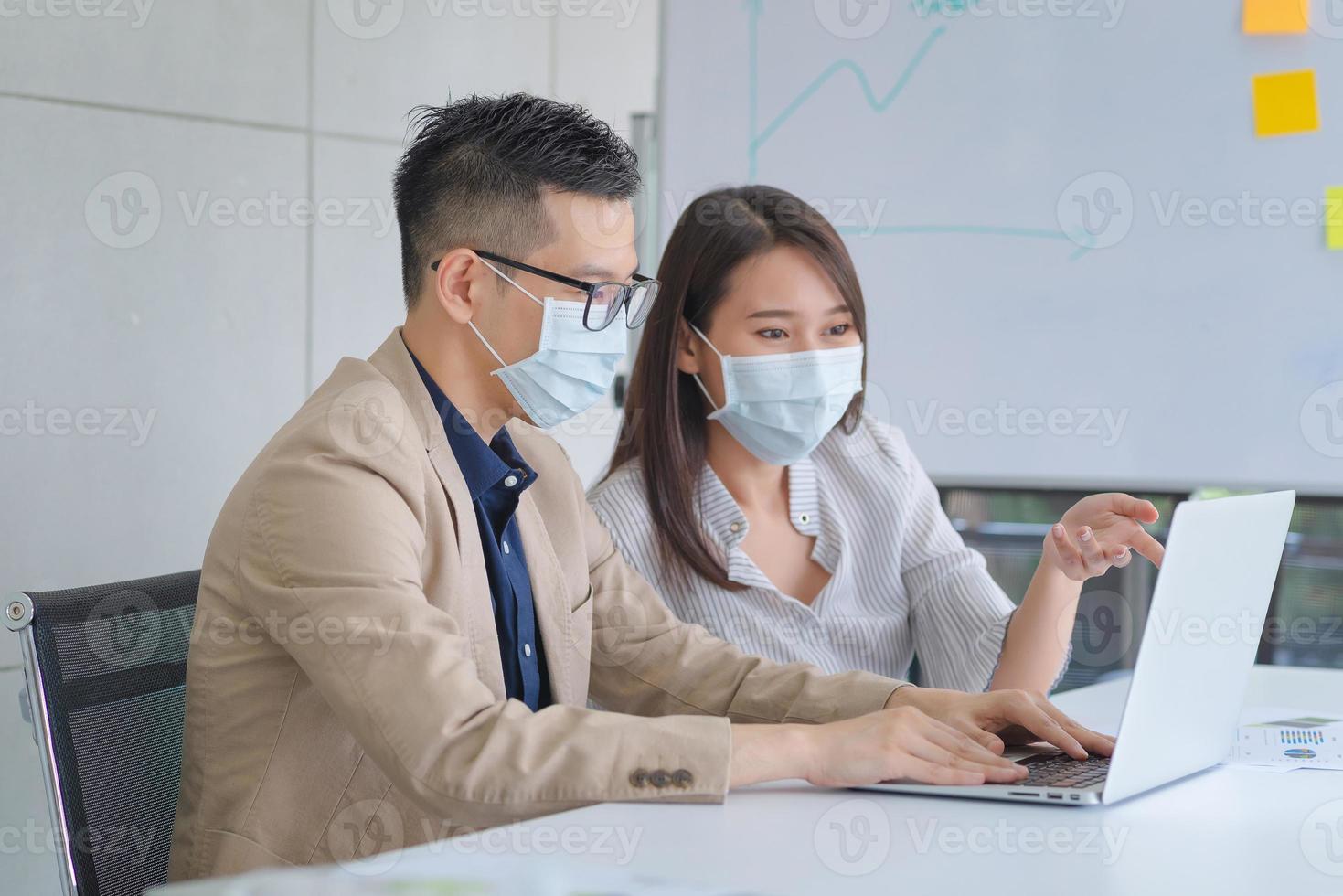 dipendenti aziendali che indossano la maschera durante il lavoro in ufficio per mantenere l'igiene seguire la politica aziendale.preventivo durante il periodo di epidemia da coronavirus o covid19. foto