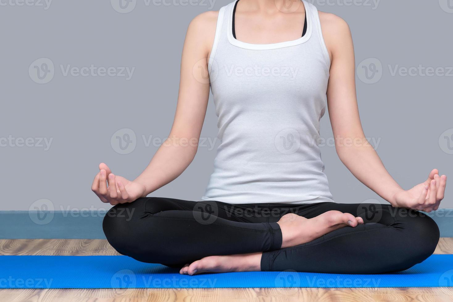 la giovane donna mantiene la calma e medita mentre pratica lo yoga per esplorare la pace interiore. lo yoga e la meditazione hanno buoni benefici per la salute. concetto di foto per lo sport yoga e uno stile di vita sano.