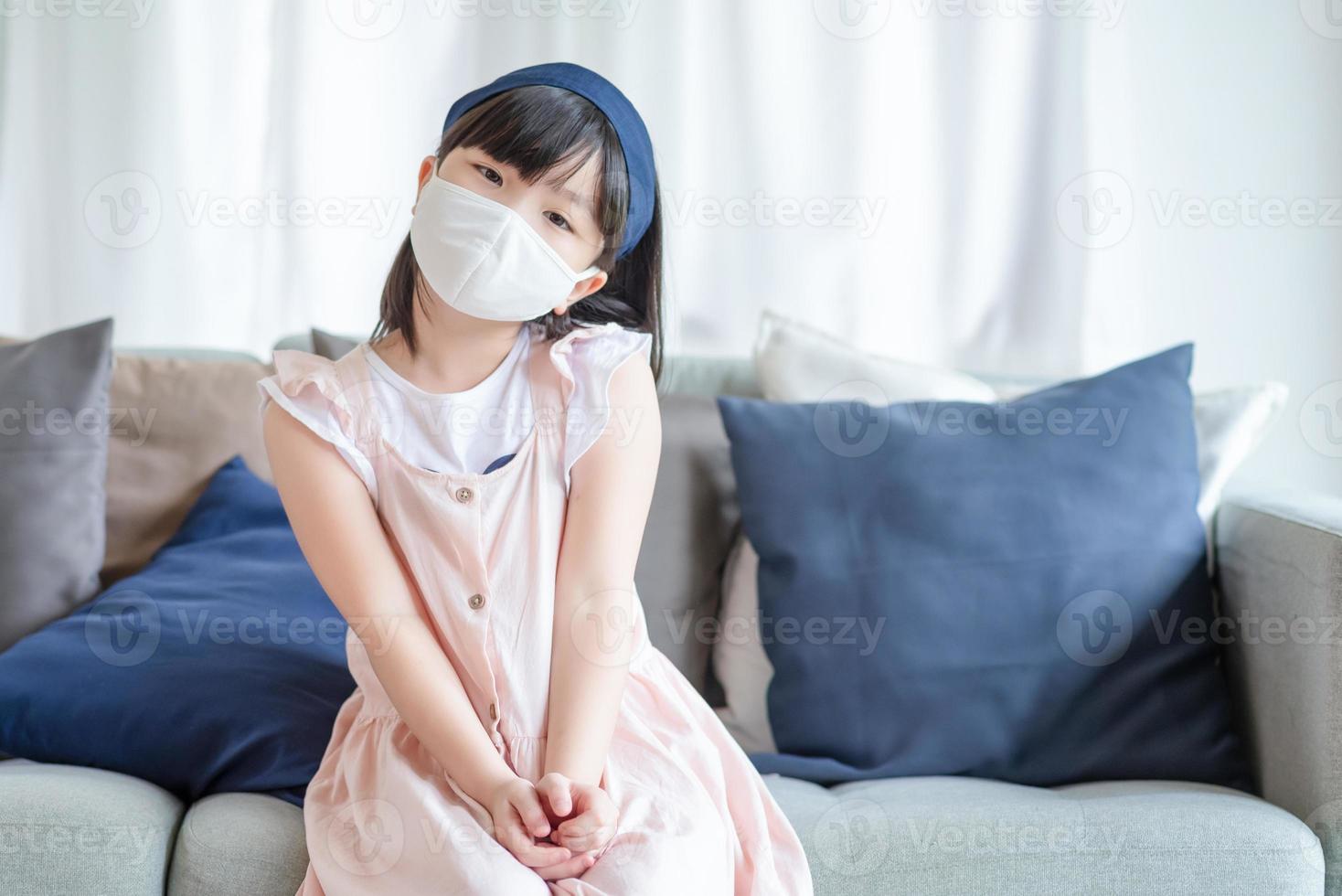 ragazza asiatica carina che indossa una maschera igienica per prevenire il coronavirus o covid-19 foto