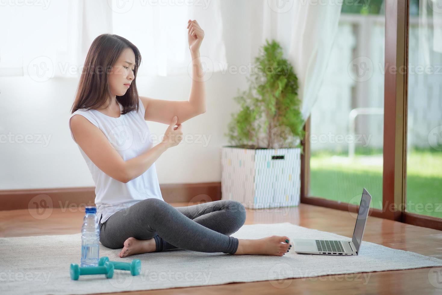 bella donna asiatica che si mantiene in forma esercitandosi a casa per uno stile di vita di tendenza sano foto