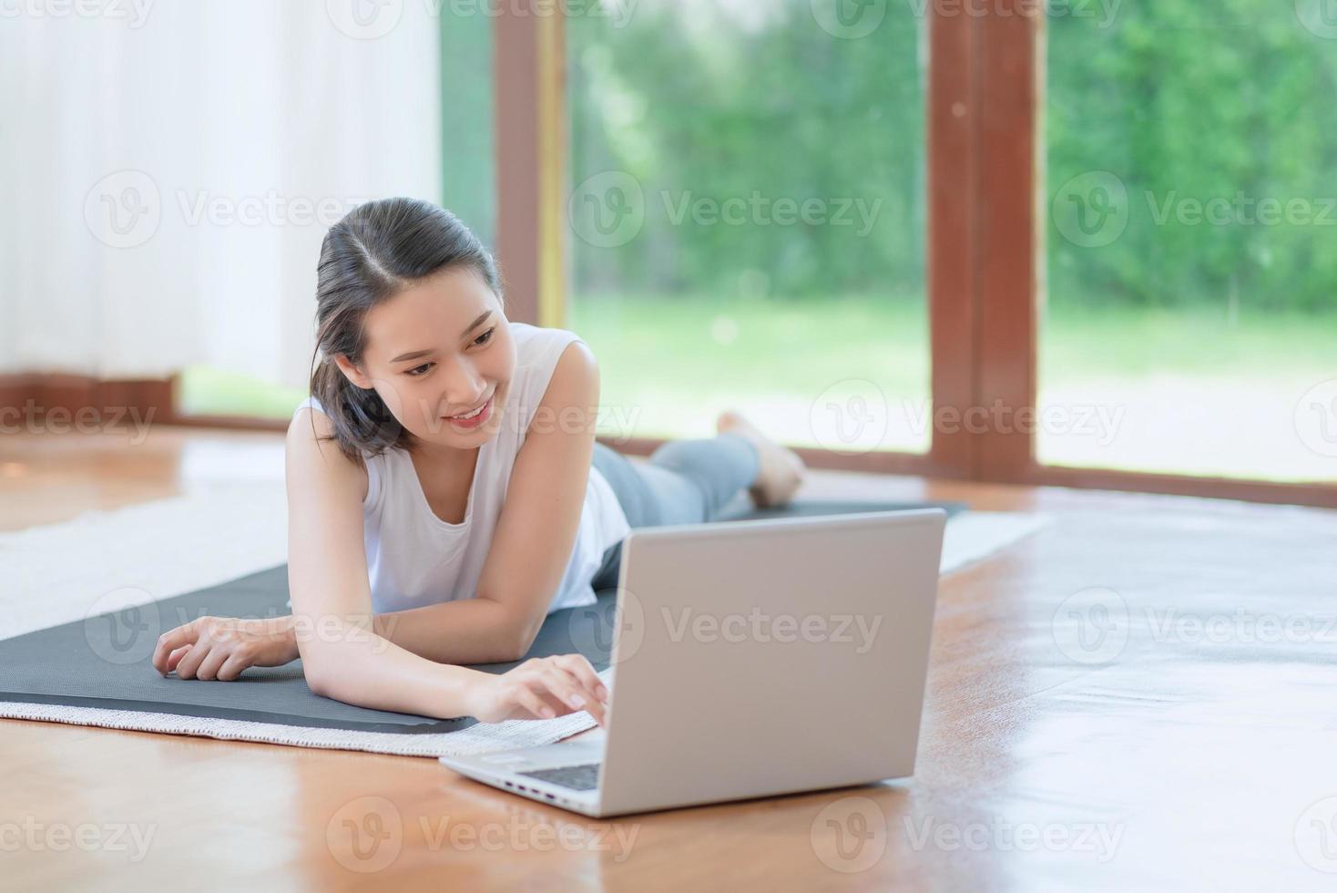 bella donna asiatica che si mantiene in forma esercitandosi a casa per uno stile di vita di tendenza sano foto