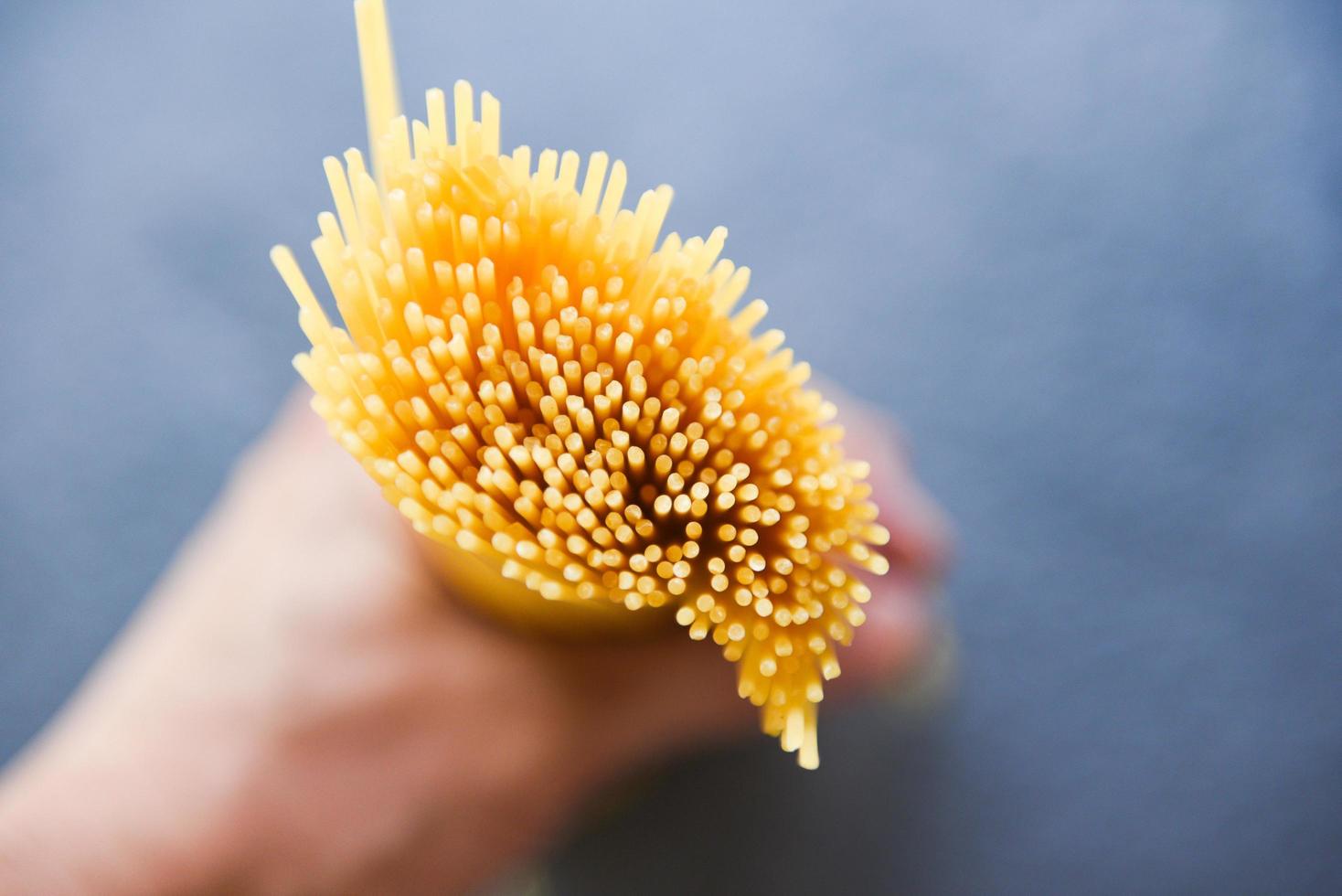 uomo con spaghetti crudi pasta italiana spaghetti crudi giallo lungo pronto per la cottura nel ristorante cibo italiano e menu foto