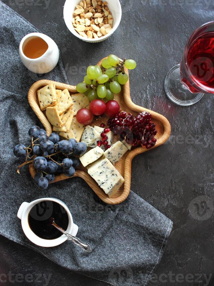 piatto di formaggi con uva e vino foto