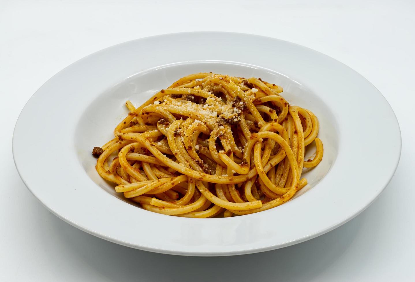 un piatto di spaghetti italiani con ragù alla bolognese e parmigiano reggiano. foto