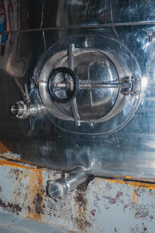 portello di manutenzione in un serbatoio di stoccaggio in acciaio inox per vino presso lo stabilimento di produzione della cantina aurora a bento goncalves. un'accogliente cittadina di campagna nel sud del Brasile famosa per la sua produzione di vino. foto