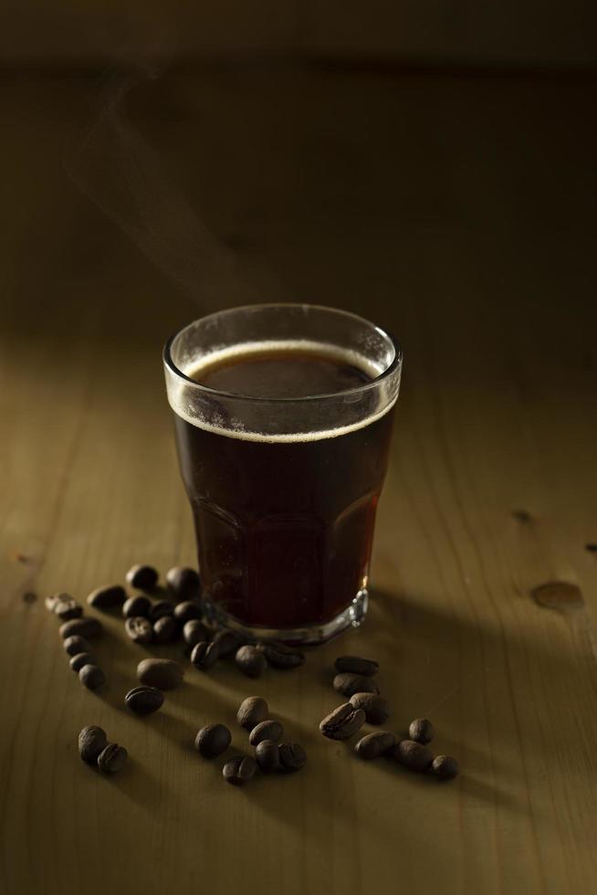 tazza di caffè e fagioli sul tavolo di legno foto