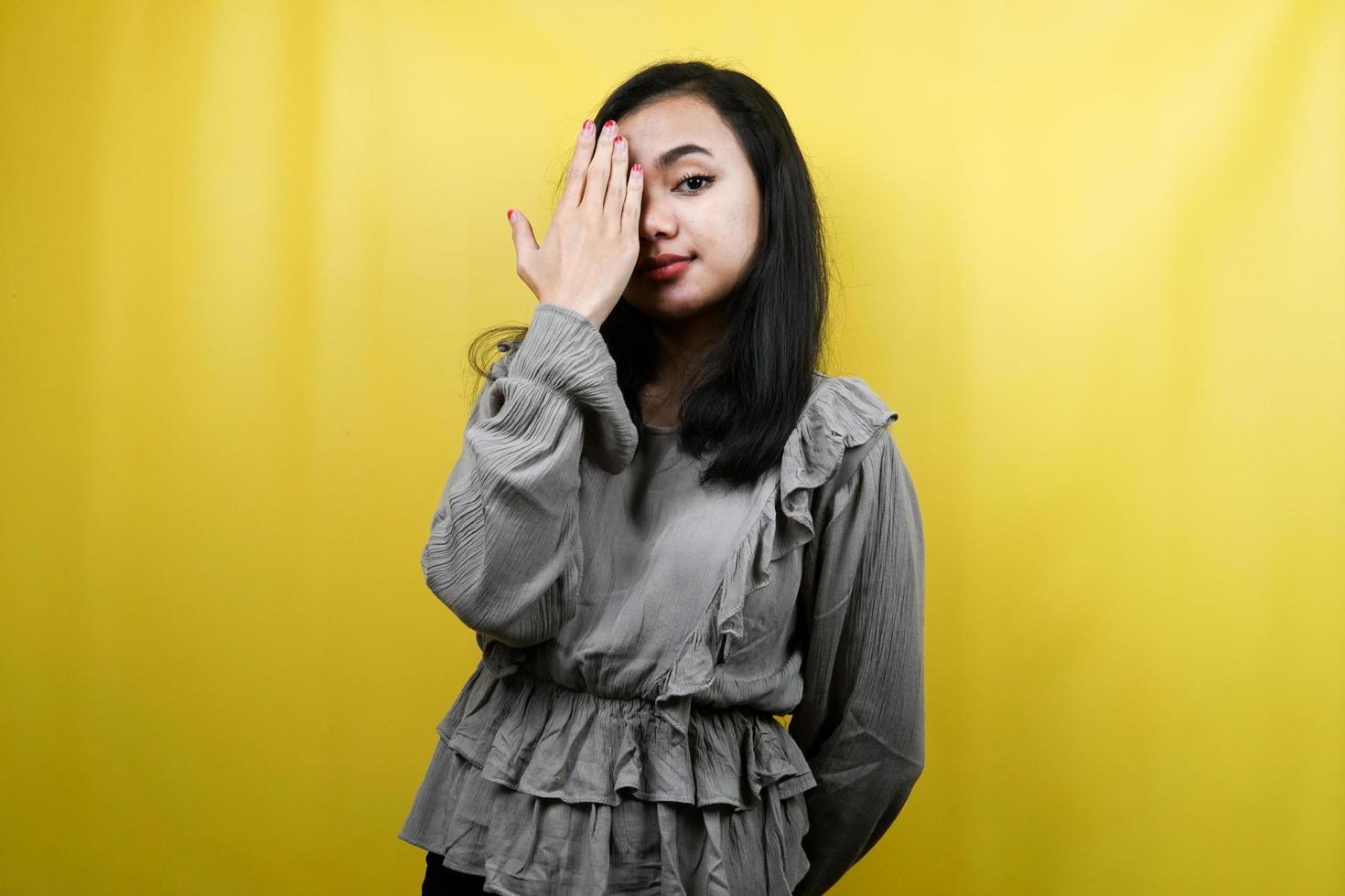 bella giovane donna con la mano chiusa un occhio isolato foto