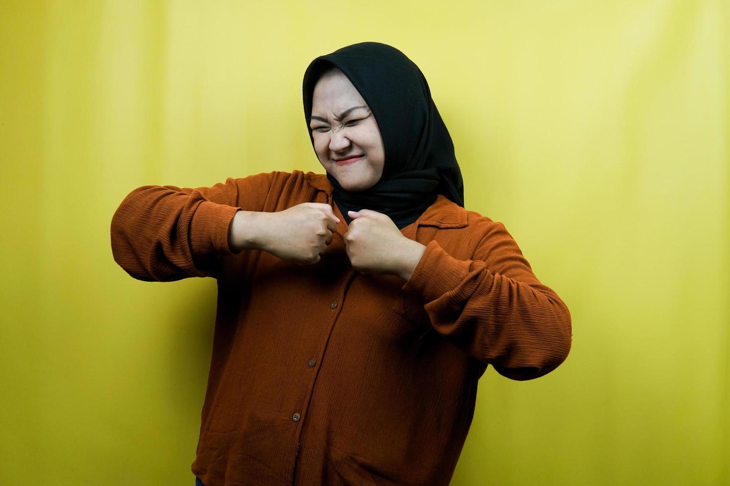 bella e allegra giovane donna musulmana asiatica, con le mani serrate, vittoria, isolata foto