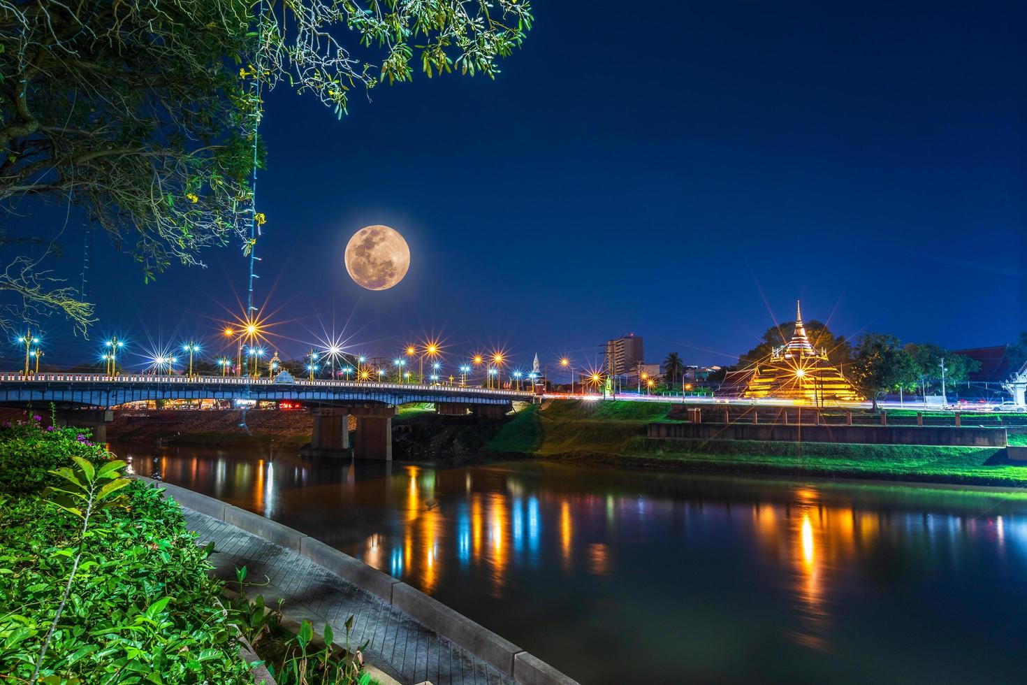 super luna piena sopra la pagoda del tempio che è un'attrazione turistica, phitsanulok, thailandia. febbraio 2019 di notte foto