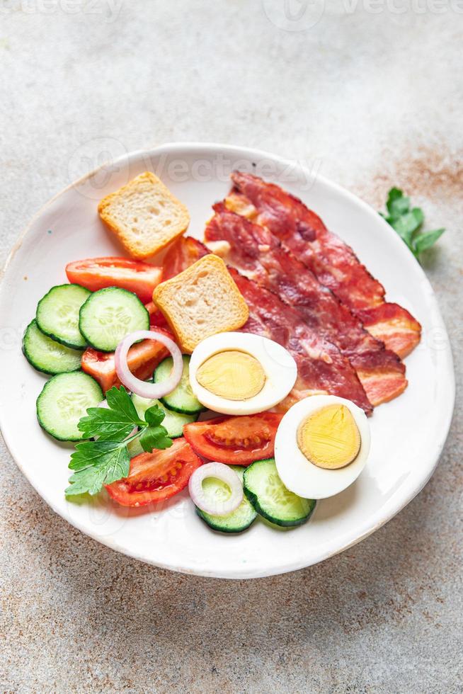 colazione inglese uova, bacon, pomodoro, cetriolo, pane tostato foto