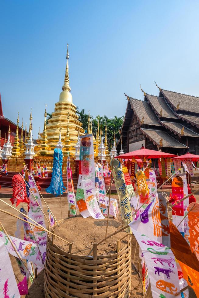 bandiere di preghiera tung appendere con ombrello o bandiera tradizionale settentrionale appendere sulla pagoda di sabbia nel tempio di phan tao per il festival di songkran è celebrato in un tradizionale giorno di capodanno a chiang mai, thailandia foto