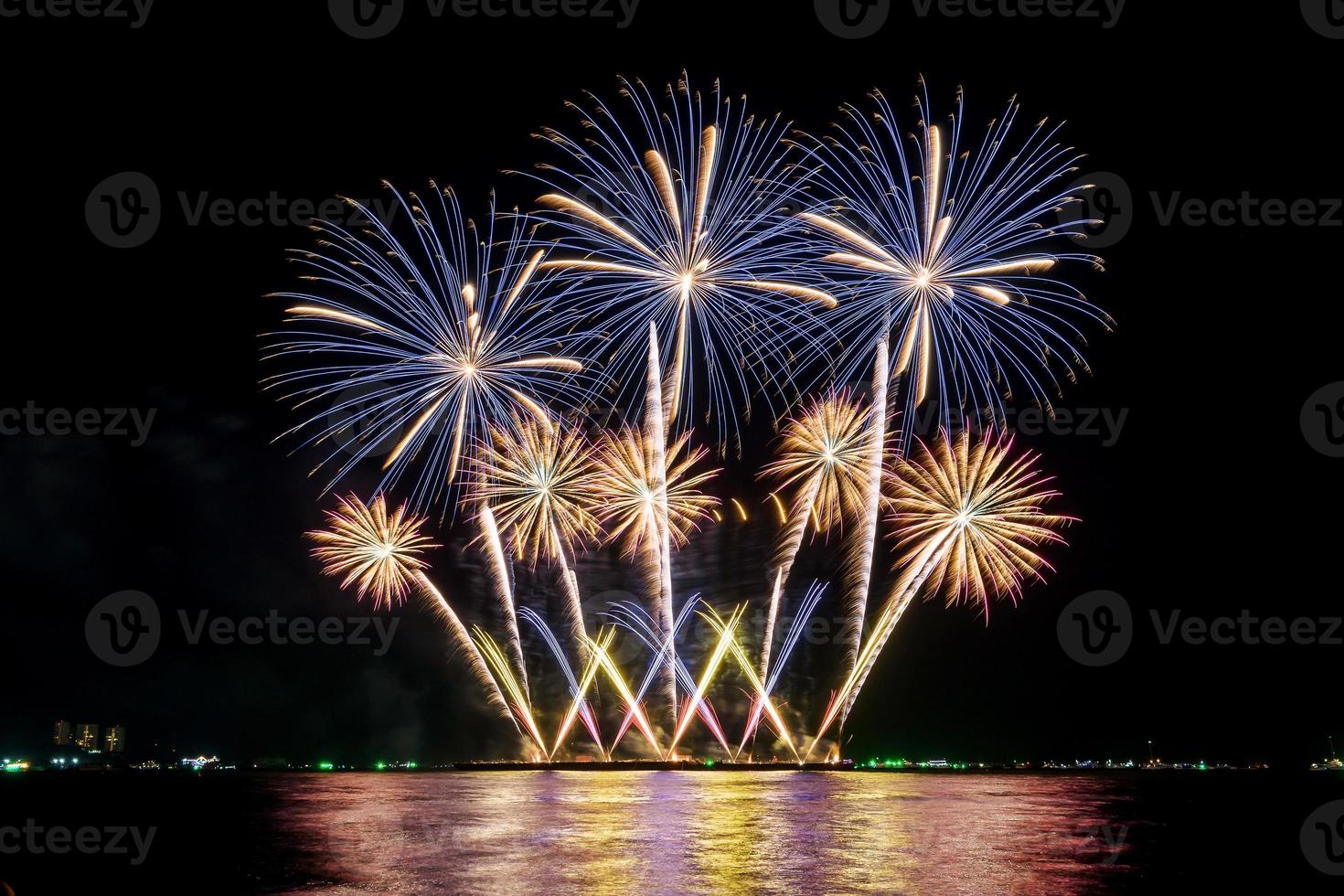 incredibile bellissimo spettacolo pirotecnico colorato nella notte di celebrazione, che mostra sulla spiaggia del mare con multi colore di riflessione sull'acqua foto