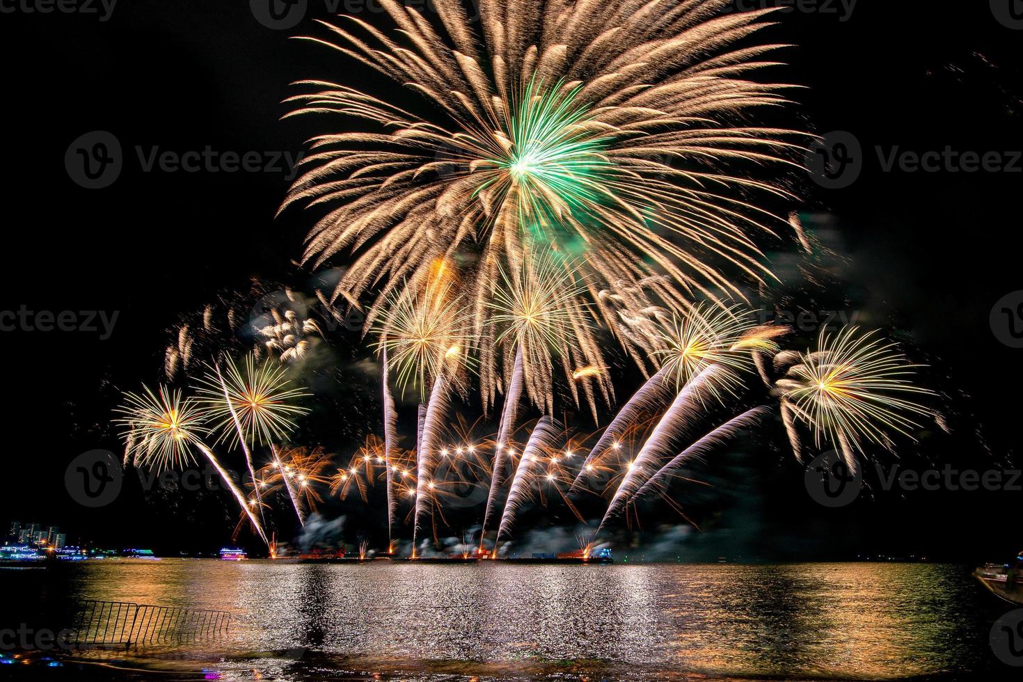 incredibile bellissimo spettacolo pirotecnico colorato nella notte di celebrazione, che mostra sulla spiaggia del mare con multi colore di riflessione sull'acqua foto