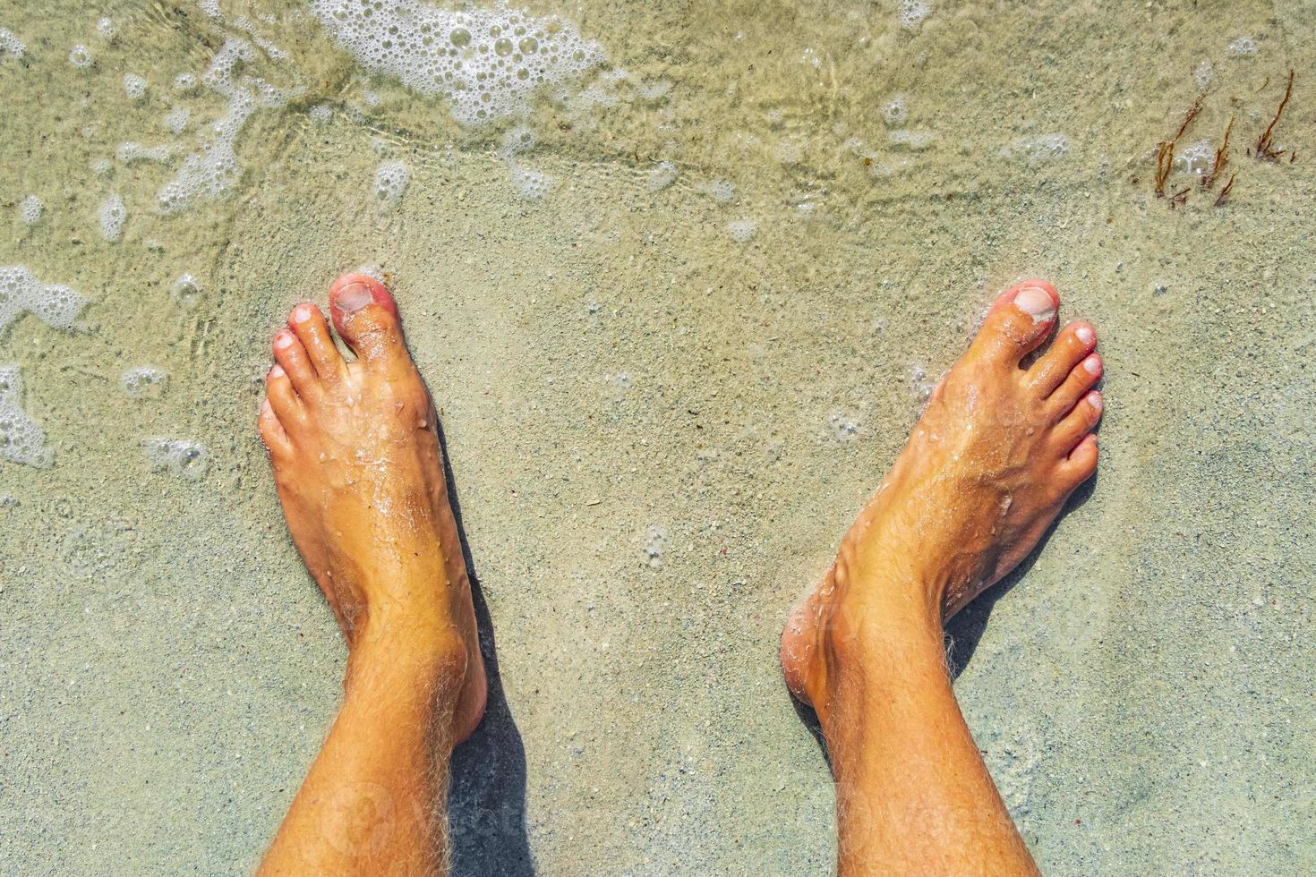 piedi in acqua e spiaggia di sabbia playa del carmen messico. foto