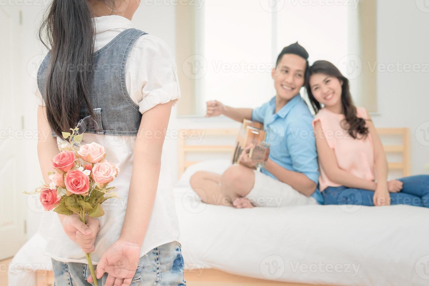 ragazza carina prepara fiori per sorprendere i suoi genitori per il loro anniversario di matrimonio. serie di foto di famiglia, bambini e concetto di persone felici.