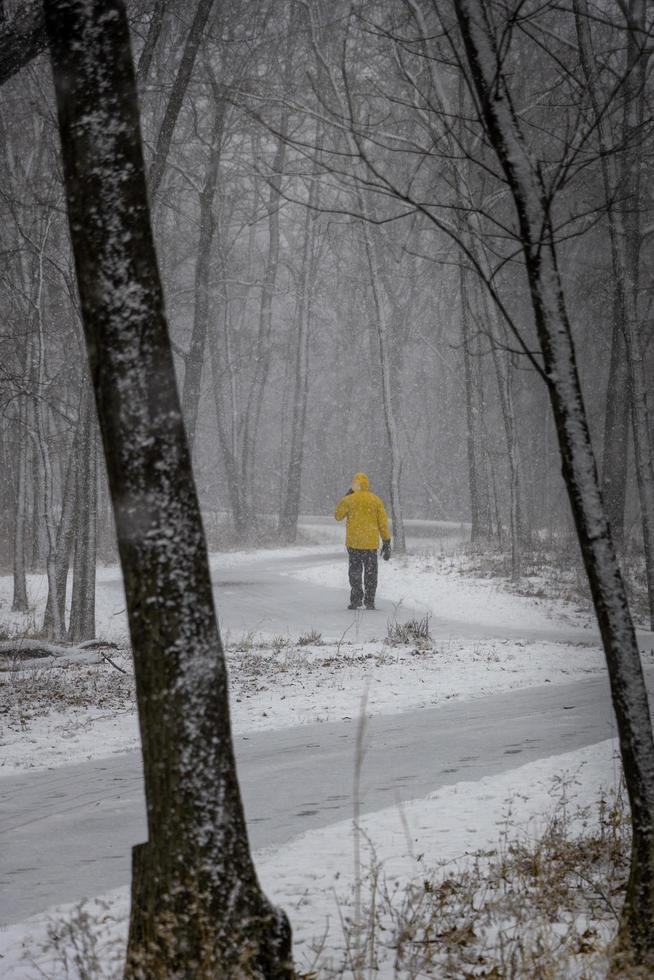 uomo che cammina in una bufera di neve foto