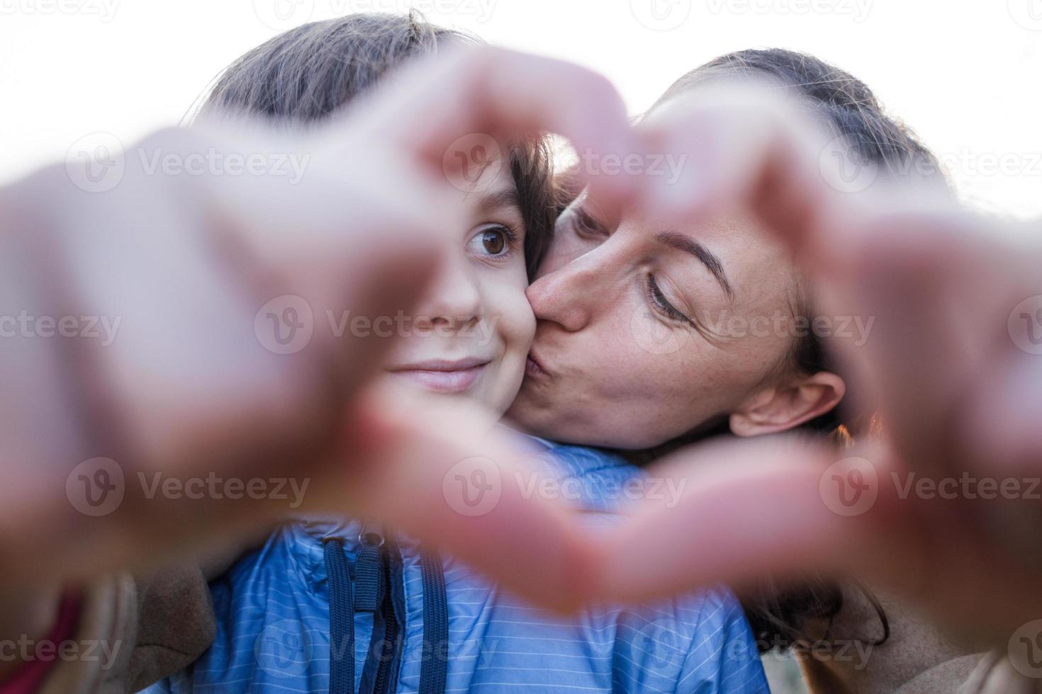 ragazzo con le dita piegate della mamma a forma di cuore. foto