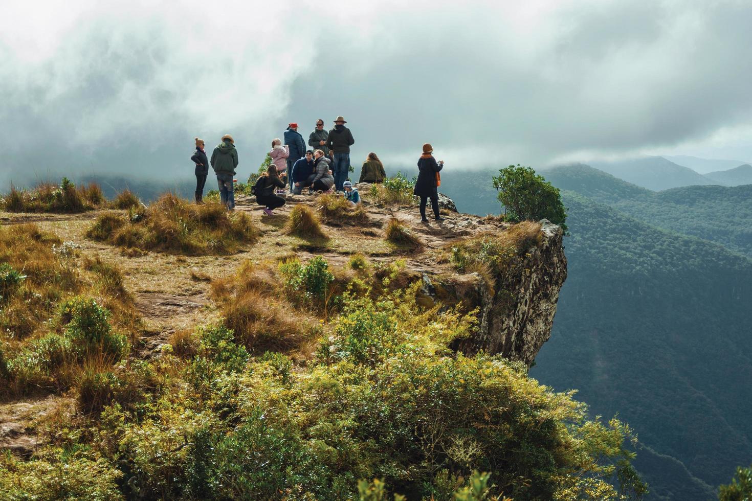 cambara do sul, brasile - 18 luglio 2019. persone sul bordo della ripida scogliera rocciosa al canyon di fortaleza in una giornata nuvolosa vicino a cambara do sul. un piccolo paese rurale con incredibili attrazioni turistiche naturali. foto