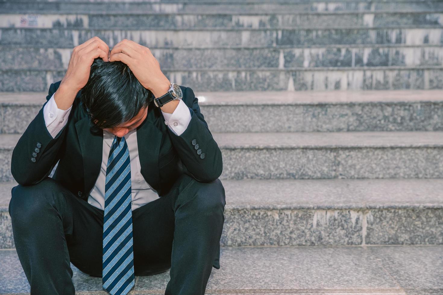 uomini d'affari asiatici con mal di testa o emicranie al municipio dopo il lavoro immagini di giovani uomini d'affari che sono stanchi, stress, crisi, depressione, fallimento nei concetti di business foto