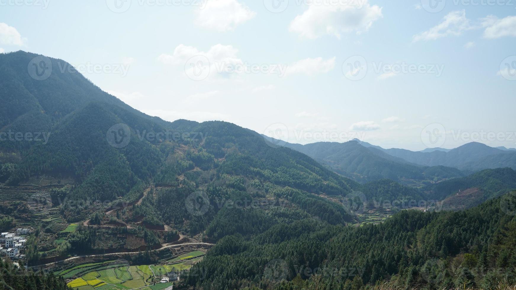 la bellissima vista sulle montagne con la foresta verde e il campo di fiori nella campagna della Cina meridionale foto