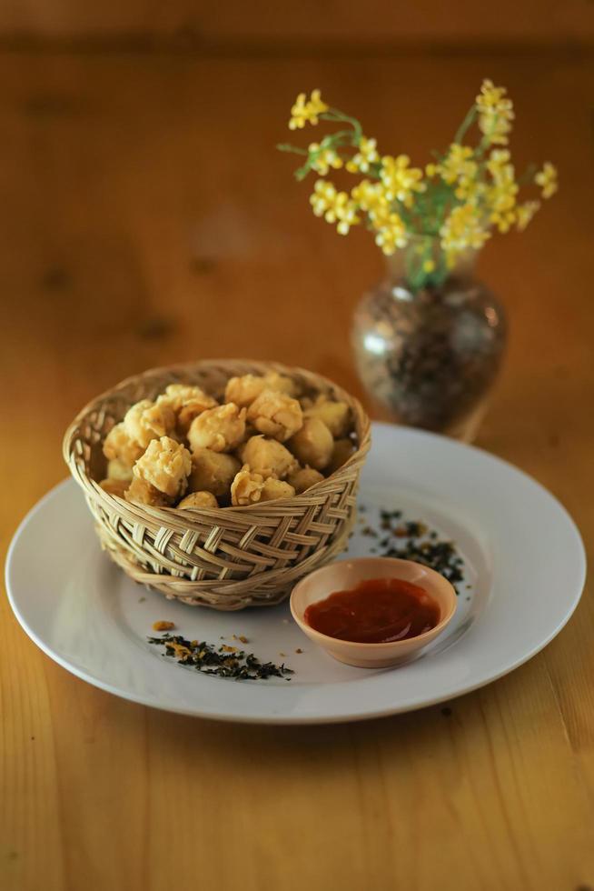 spuntino di patate fritte in una ciotola e la salsa in tavola foto