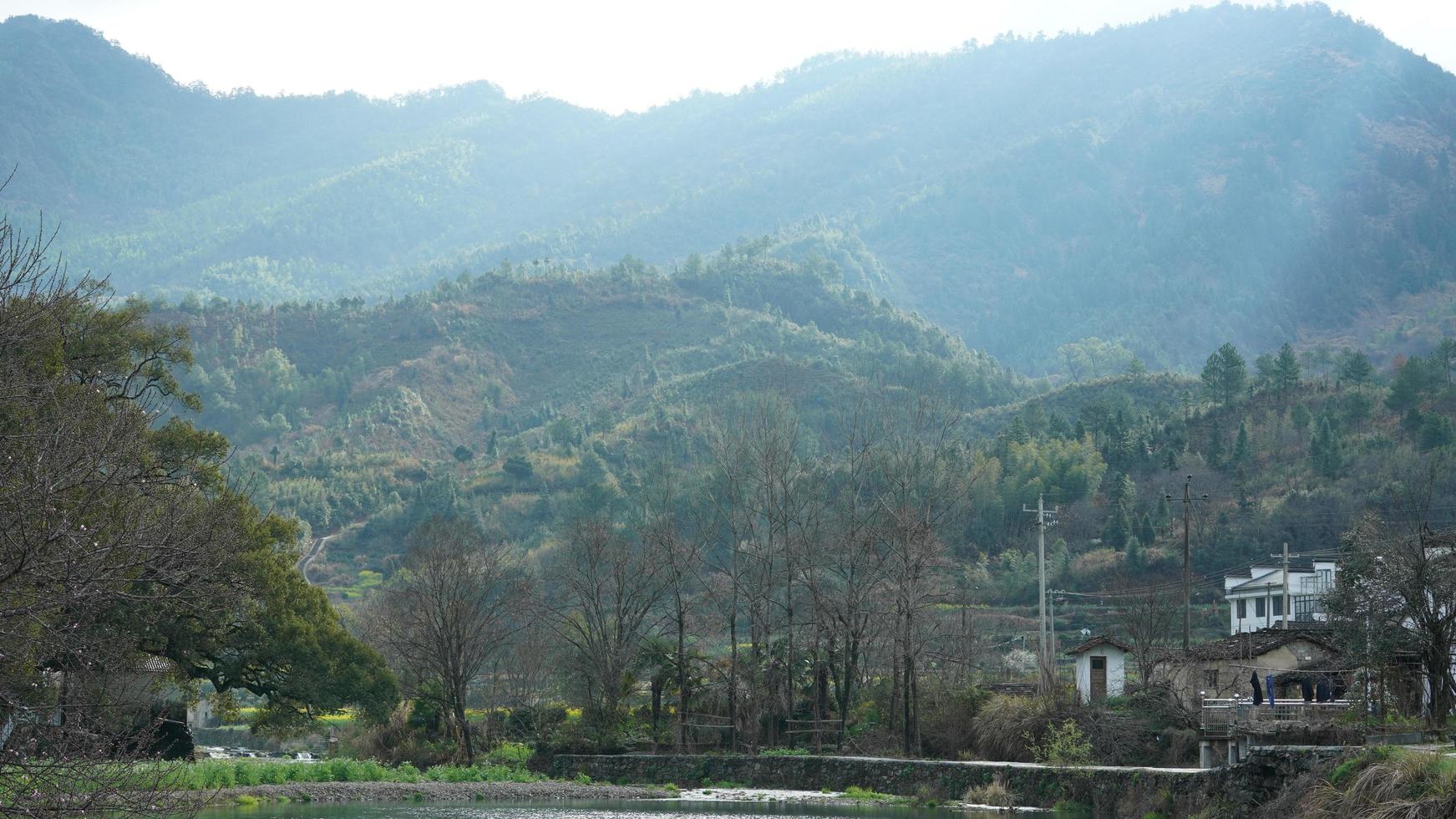 la bella e antica vista del villaggio tradizionale cinese con le montagne intorno situata nella campagna della Cina meridionale foto