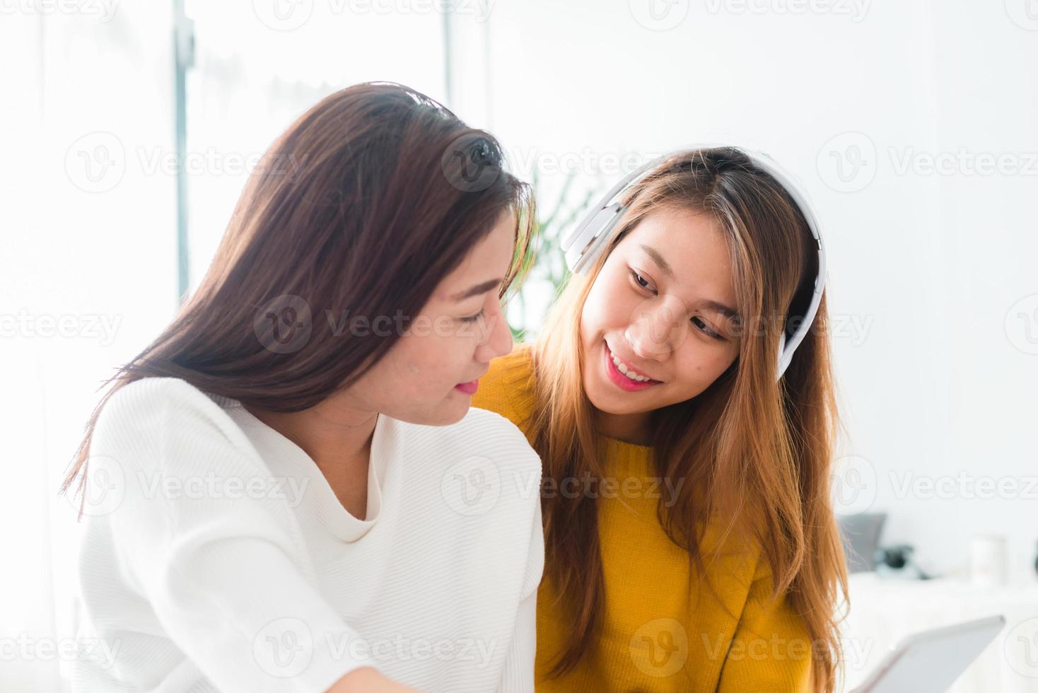 giovane coppia lesbica asiatica che ascolta musica insieme in un felice momento d'amore in camera da letto. coppia lgbt che ascolta la musica in un'emozione d'amore. coppia di amore lgbt nel concetto di camera da letto. foto