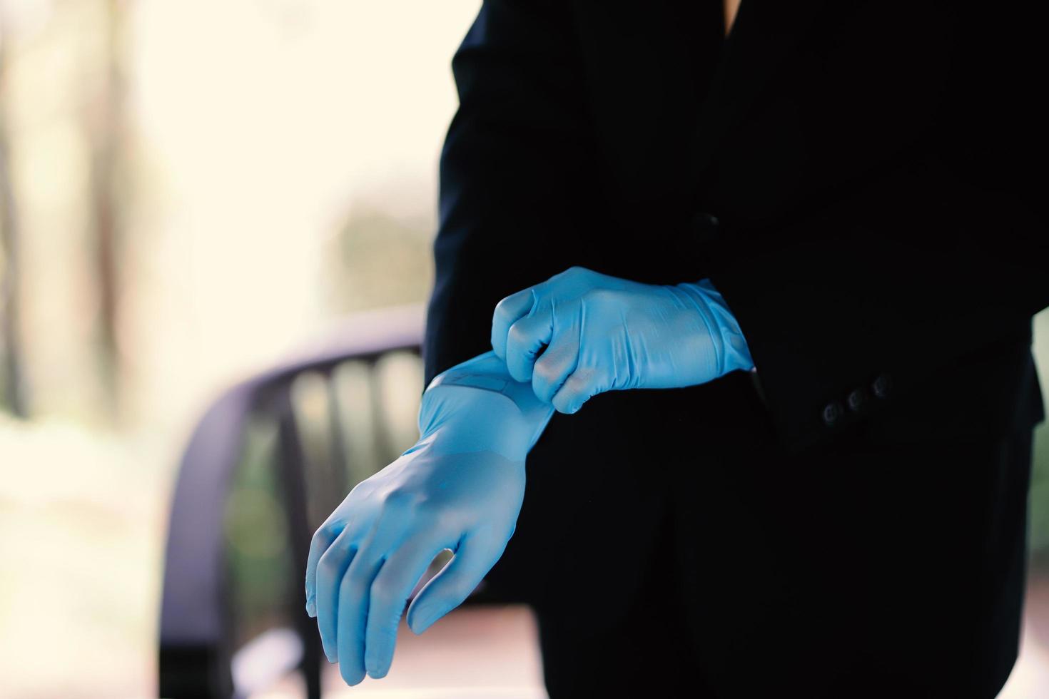 le mani di un uomo che indossa guanti blu che si prepara per un evento foto