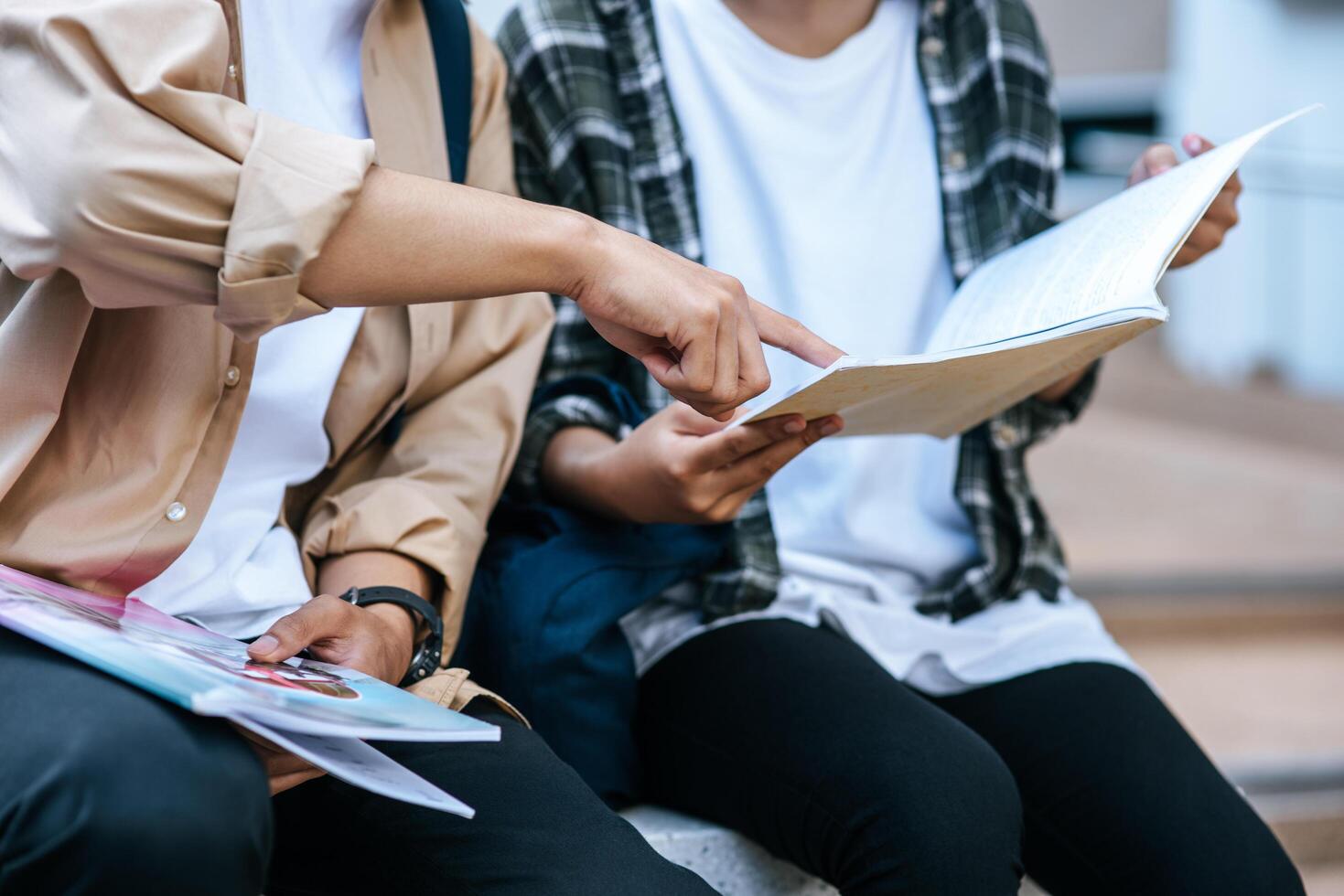 studenti maschi e femmine che indossano maschere si siedono e leggono libri sulle scale foto