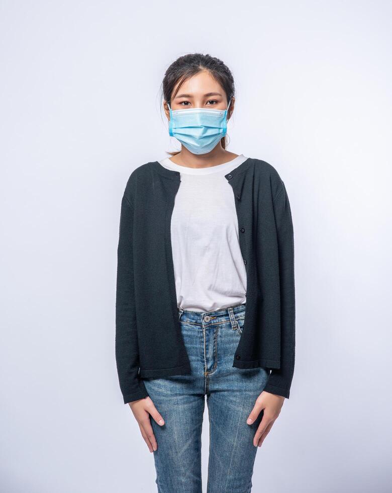 una donna è malata in piedi indossando una maschera. foto