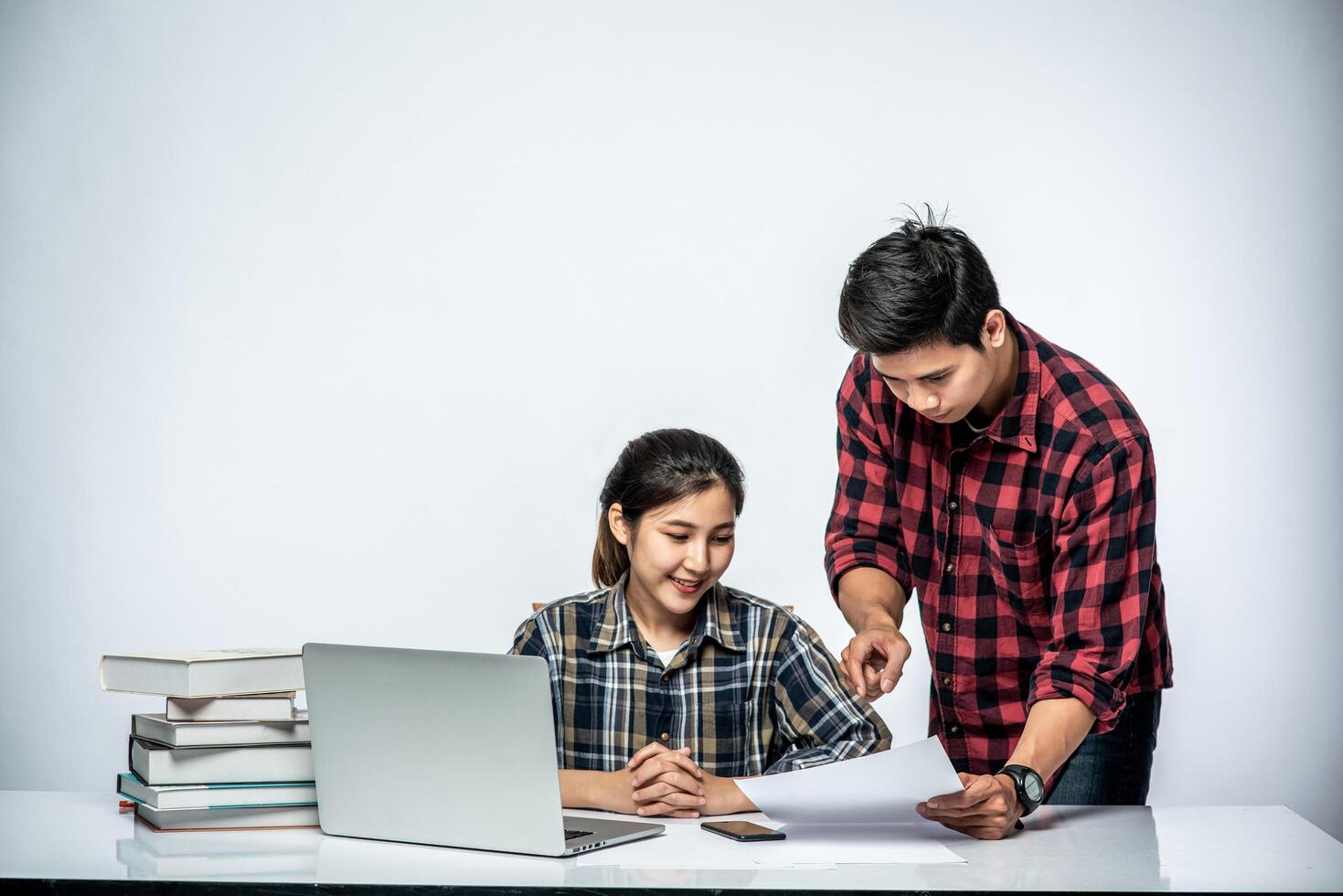 gli uomini insegnano alle donne come lavorare con i laptop al lavoro. foto