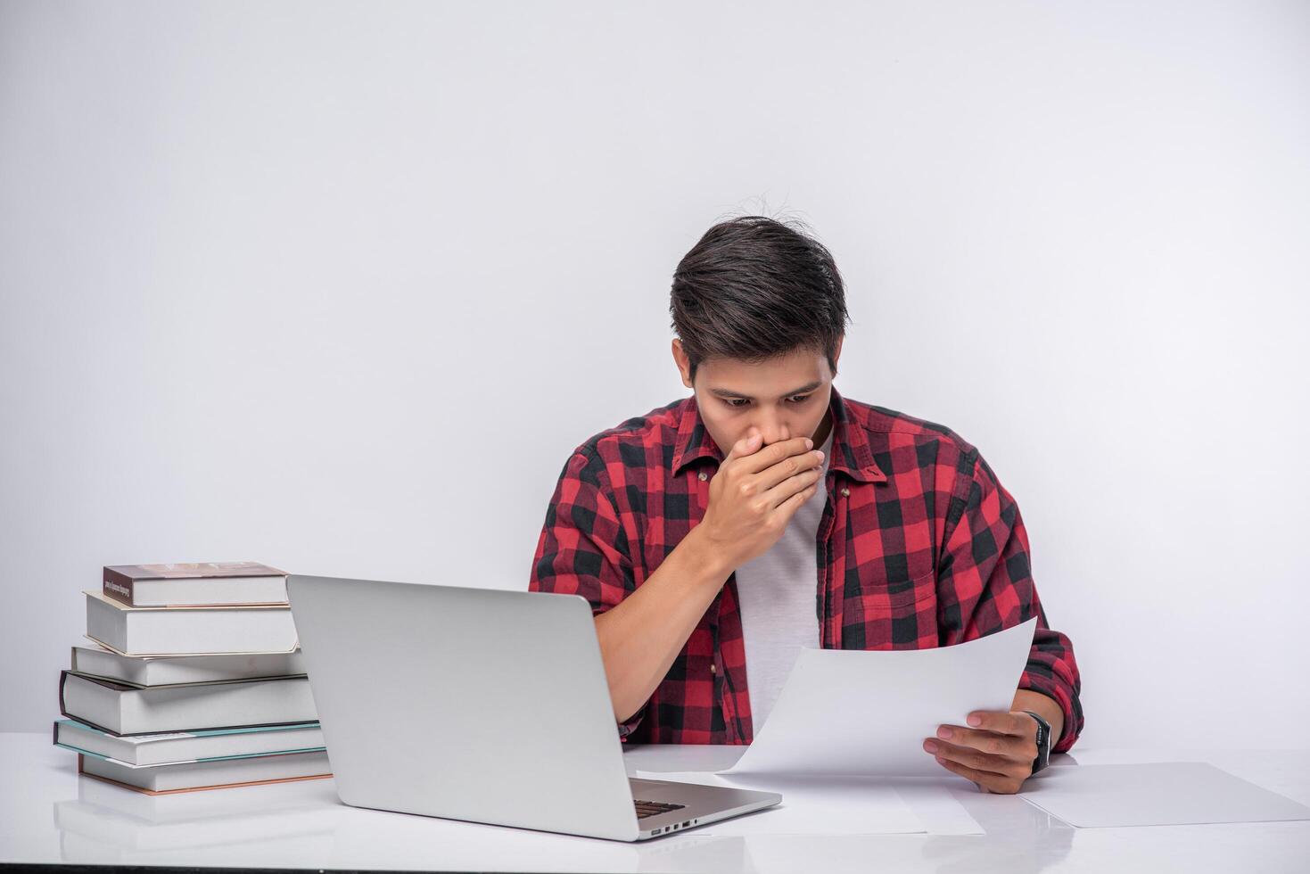 un uomo che usa un laptop in ufficio e fa un'analisi dei documenti. foto