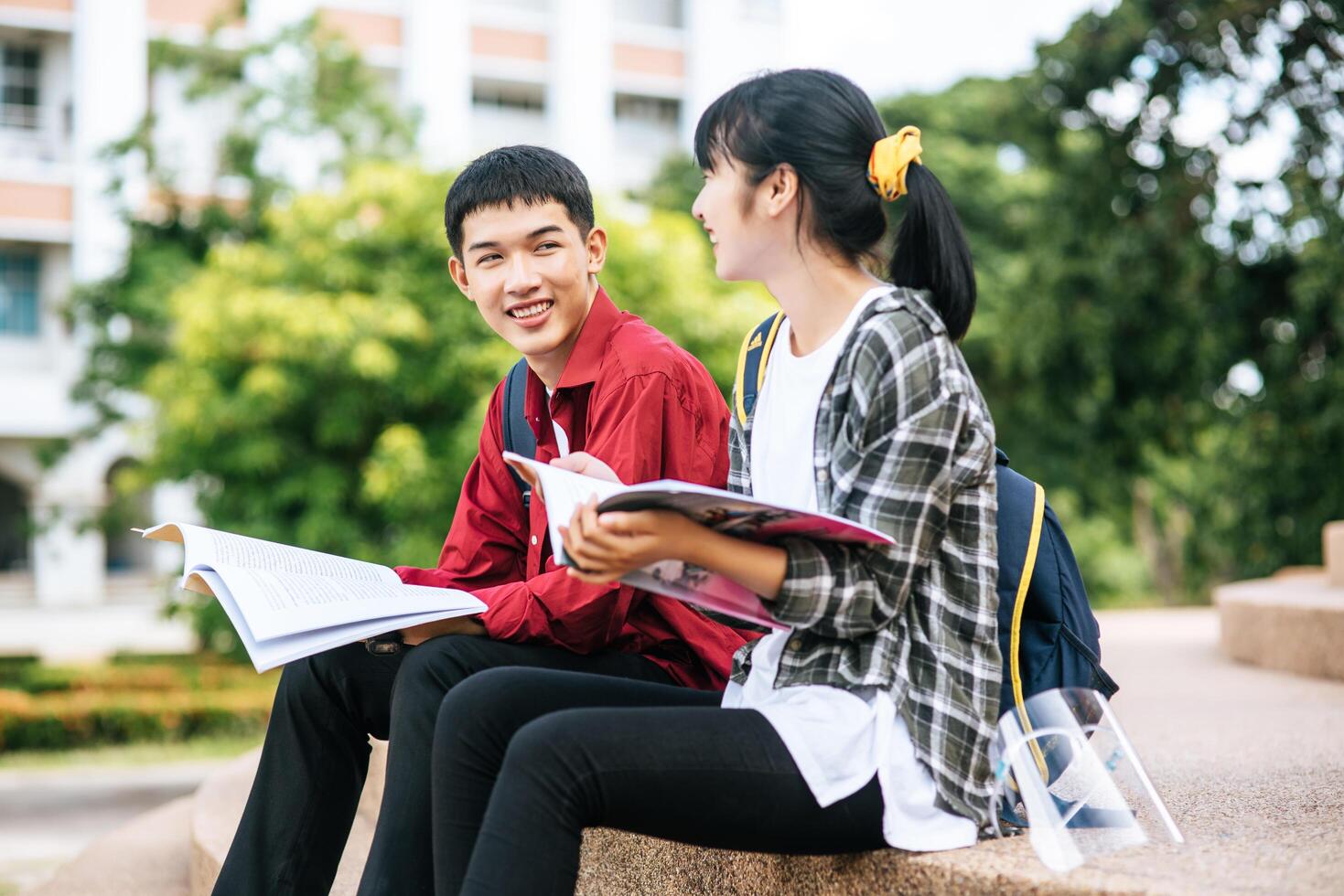 studenti maschi e femmine seduti e leggere libri sulle scale. foto