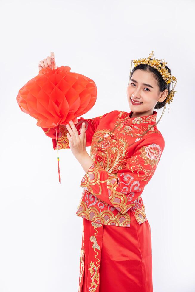 la donna indossa un abito cheongsam promuove la lampada rossa al cliente nel capodanno cinese foto