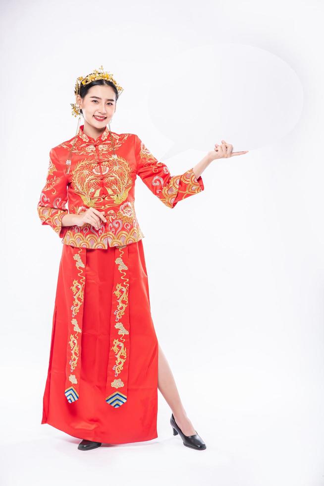la donna indossa una tuta cheongsam e una scarpa nera felice di ricevere cose nuove per sorprendere nel capodanno cinese foto