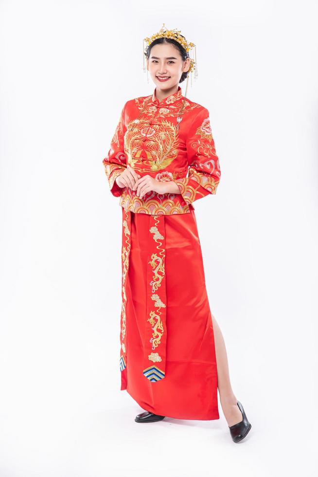 la donna indossa un abito cheongsam sorride per dare il benvenuto ai viaggiatori che fanno shopping nel capodanno cinese foto
