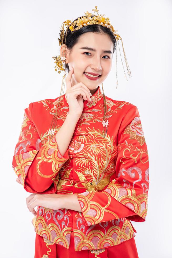 la donna indossa un abito cheongsam sorride per dare il benvenuto ai viaggiatori che fanno shopping nel capodanno cinese foto