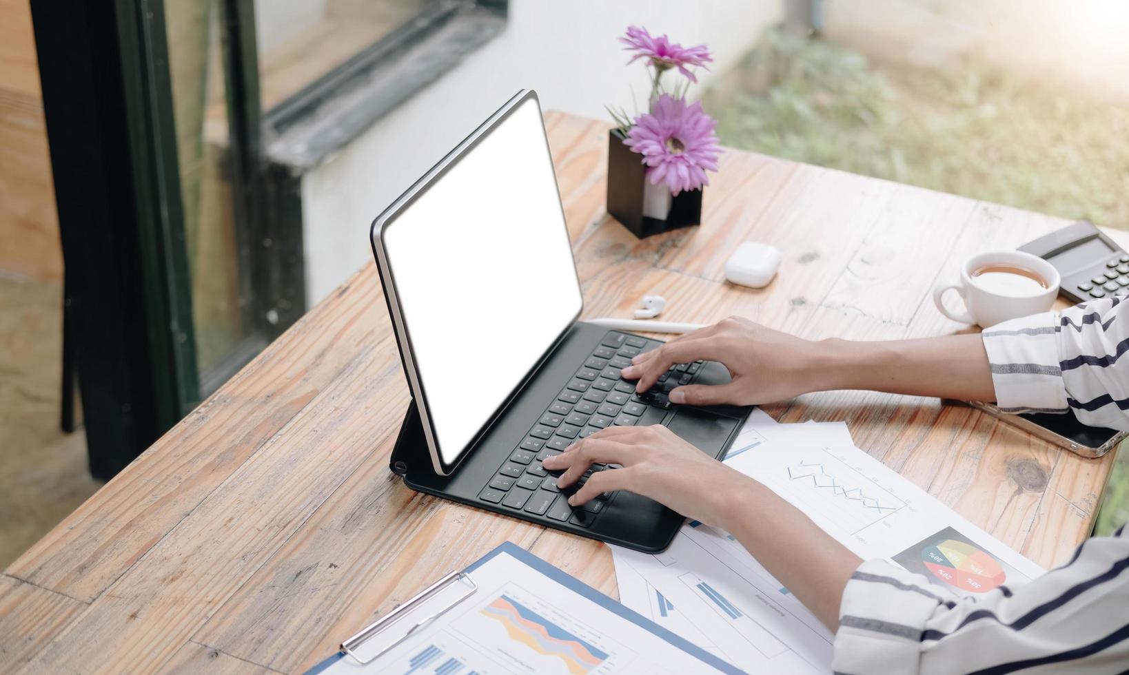 donna d'affari che utilizza lo schermo vuoto del laptop mentre si lavora con la calcolatrice per scopi finanziari. tracciato di ritaglio foto