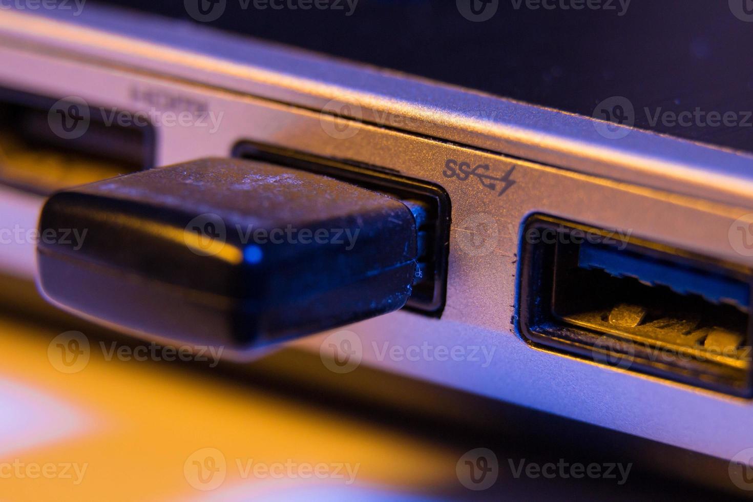 primo piano dell'unità flash USB inserita nella porta sul lato di un laptop foto