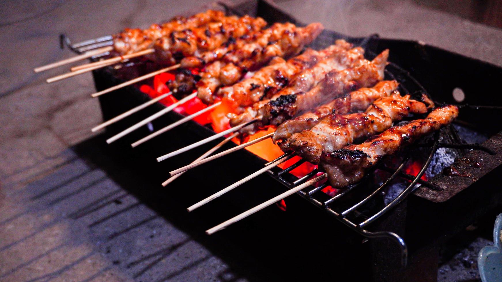 il processo di preparazione del cibo satay, grigliato sui carboni ardenti foto