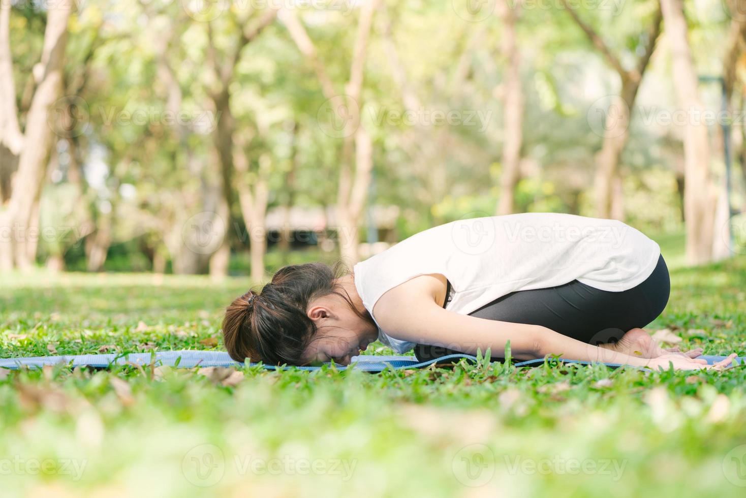 giovane donna asiatica yoga all'aperto mantiene la calma e medita mentre pratica yoga per esplorare la pace interiore. lo yoga e la meditazione hanno buoni benefici per la salute. sport yoga e concetto di stile di vita sano. foto